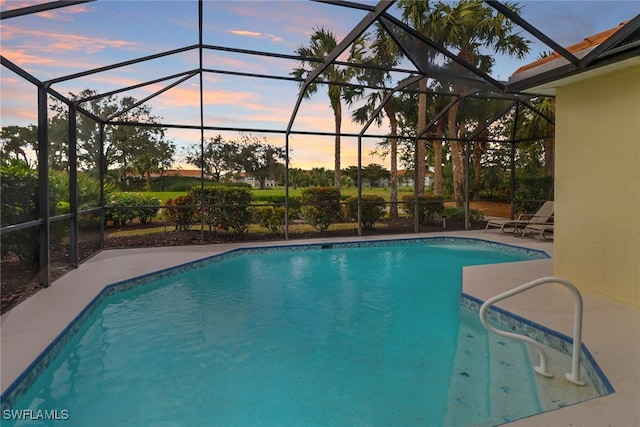 pool at dusk featuring a lanai and a patio