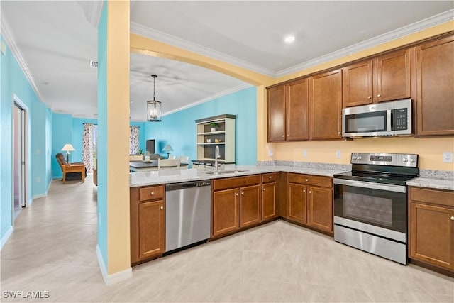 kitchen with light stone countertops, appliances with stainless steel finishes, crown molding, sink, and pendant lighting