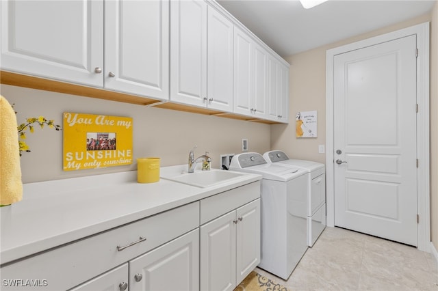 laundry room featuring cabinets, sink, light tile patterned floors, and washer and clothes dryer