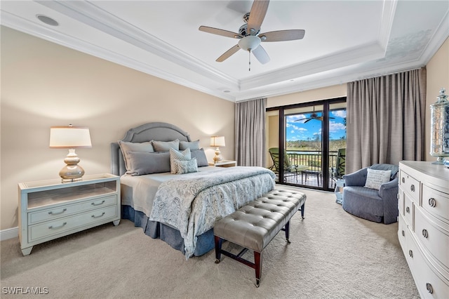 bedroom with a raised ceiling, light carpet, and access to outside