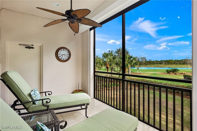 sunroom featuring a water view and ceiling fan