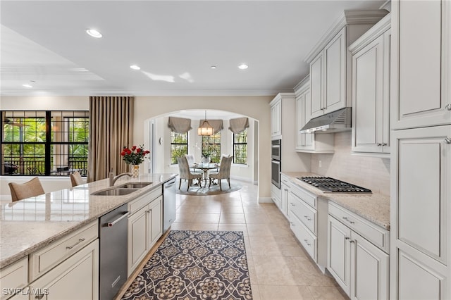 2550 Marquesa Royale Ln Unit 8-101, Naples, FL 34109 - kitchen with arched walkways, stainless steel appliances, a sink, ornamental molding, and under cabinet range hood