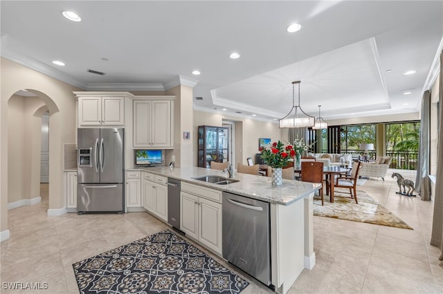 2550 Marquesa Royale Ln Unit 8-101, Naples, FL 34109 - kitchen featuring crown molding, appliances with stainless steel finishes, arched walkways, a sink, and a peninsula