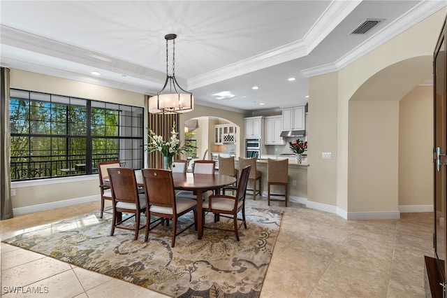2550 Marquesa Royale Ln Unit 8-101, Naples, FL 34109 - dining space with crown molding, arched walkways, visible vents, and a raised ceiling