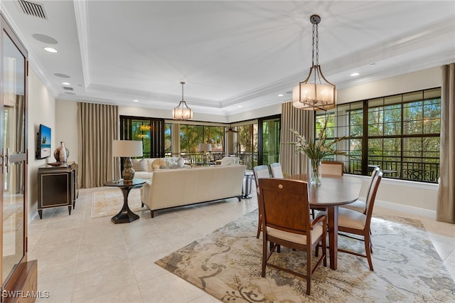 tiled dining space with an inviting chandelier, ornamental molding, and a raised ceiling