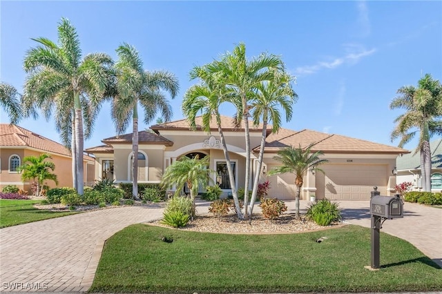 mediterranean / spanish-style home featuring a garage and a front lawn