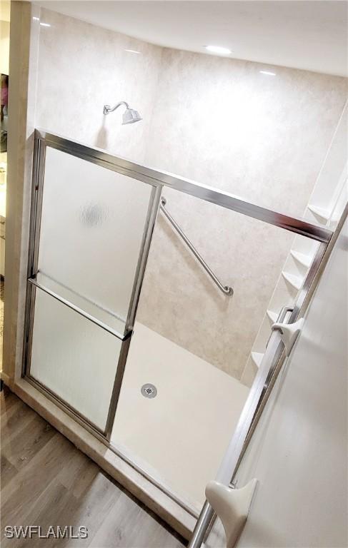 bathroom featuring hardwood / wood-style flooring and walk in shower