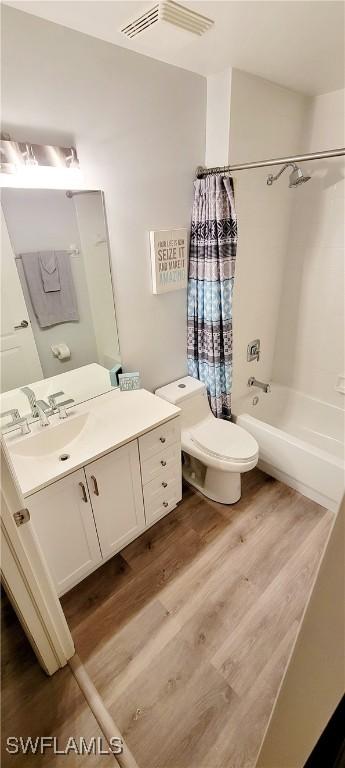 full bathroom featuring shower / tub combo, vanity, toilet, and wood-type flooring