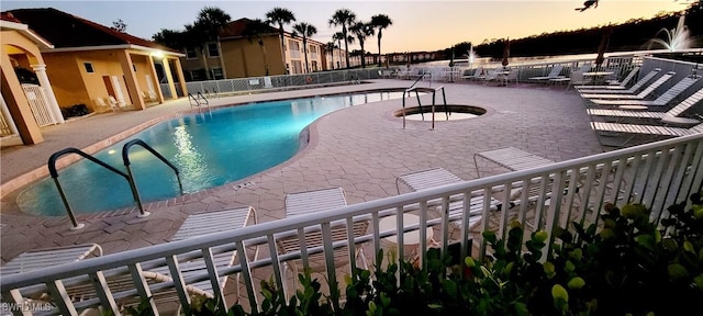 pool at dusk featuring a patio