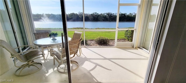 sunroom / solarium featuring plenty of natural light and a water view