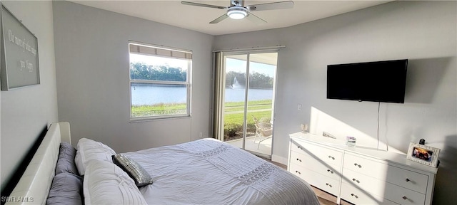 bedroom with access to exterior, wood-type flooring, and ceiling fan