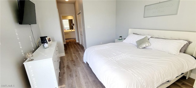 bedroom featuring wood-type flooring and ensuite bath