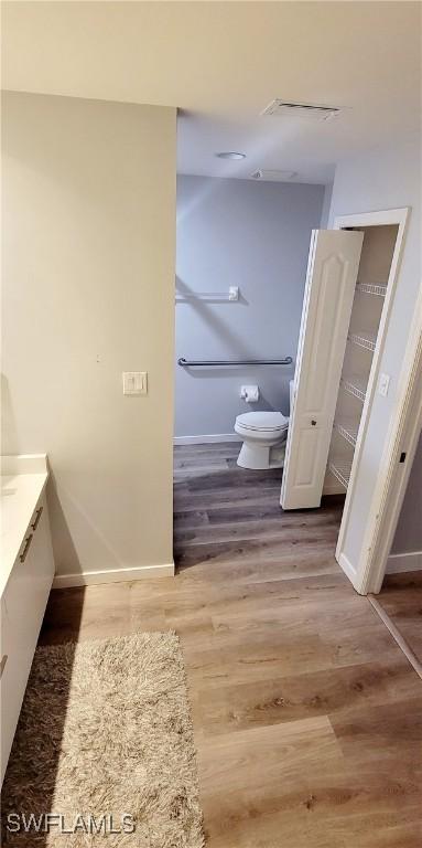 bathroom featuring vanity, hardwood / wood-style flooring, and toilet