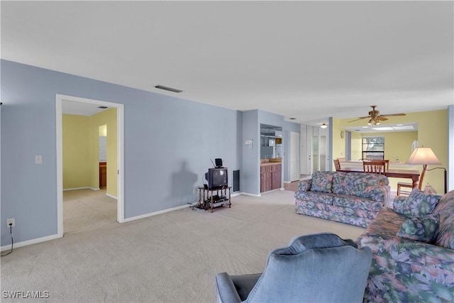 carpeted living room with ceiling fan