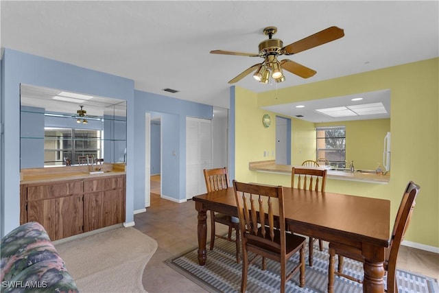 dining area with ceiling fan and sink