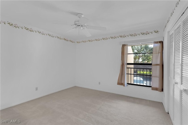 spare room featuring ceiling fan and light colored carpet