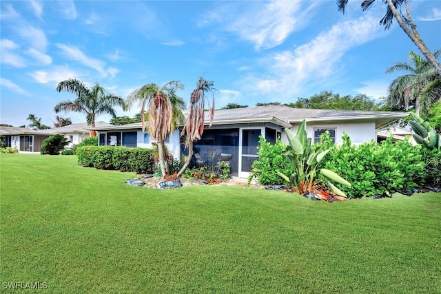 view of front of home with a front yard and a sunroom