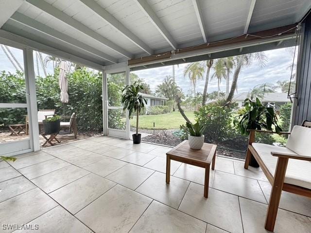 unfurnished sunroom featuring beamed ceiling