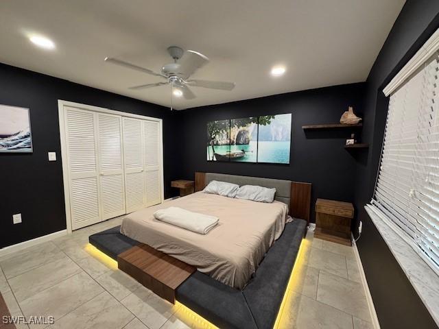 bedroom featuring a closet, ceiling fan, and light tile patterned floors