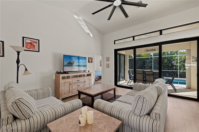 living room with ceiling fan, lofted ceiling, and light hardwood / wood-style flooring