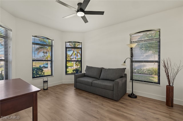 sitting room featuring wood-type flooring, ceiling fan, and a healthy amount of sunlight