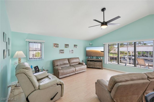 living room featuring ceiling fan, vaulted ceiling, and light wood-type flooring