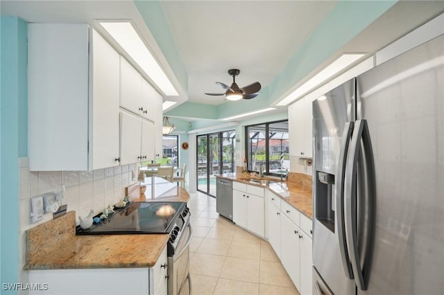 kitchen featuring white cabinets, ceiling fan, stainless steel appliances, and stone counters