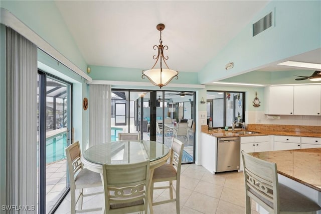 dining room featuring ceiling fan, lofted ceiling, sink, and light tile patterned floors