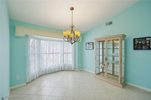 tiled empty room with a chandelier and vaulted ceiling