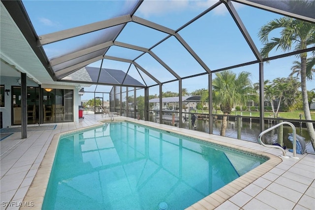 view of swimming pool with glass enclosure, a patio area, and a water view