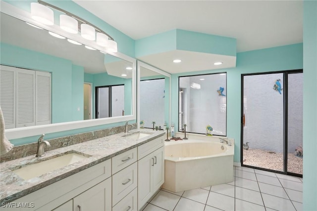 bathroom featuring a washtub, vanity, and tile patterned flooring