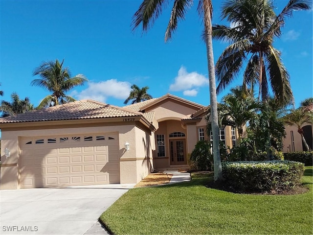 mediterranean / spanish-style house with a garage and a front lawn