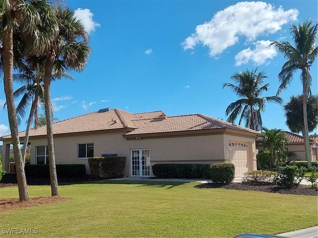 back of house with a yard, french doors, and a garage