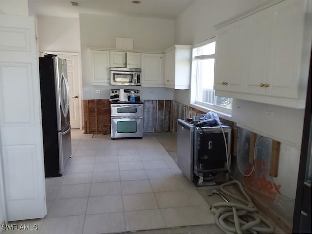 kitchen with white cabinets, light tile patterned flooring, and stainless steel appliances