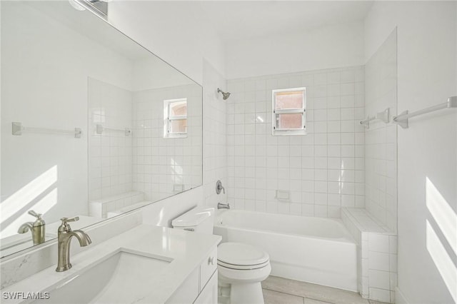 full bathroom featuring tile patterned flooring, vanity, toilet, and tiled shower / bath