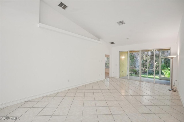 tiled spare room with vaulted ceiling