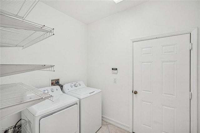 clothes washing area featuring washer and dryer and light tile patterned flooring