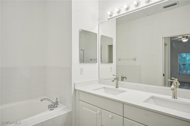 bathroom with tiled bath and vanity