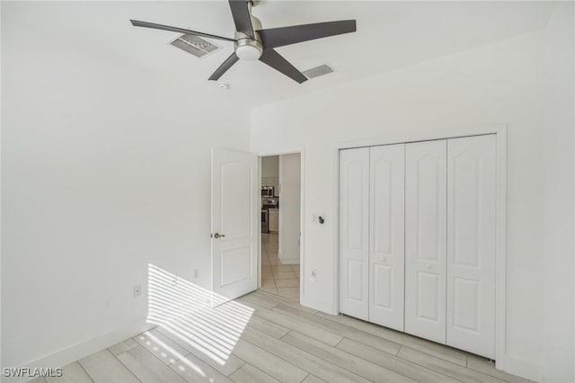 unfurnished bedroom with light hardwood / wood-style floors, a closet, and ceiling fan