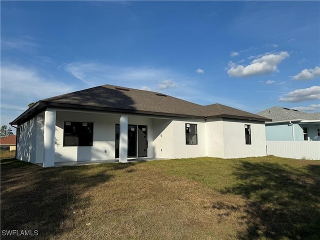 rear view of property with a lawn