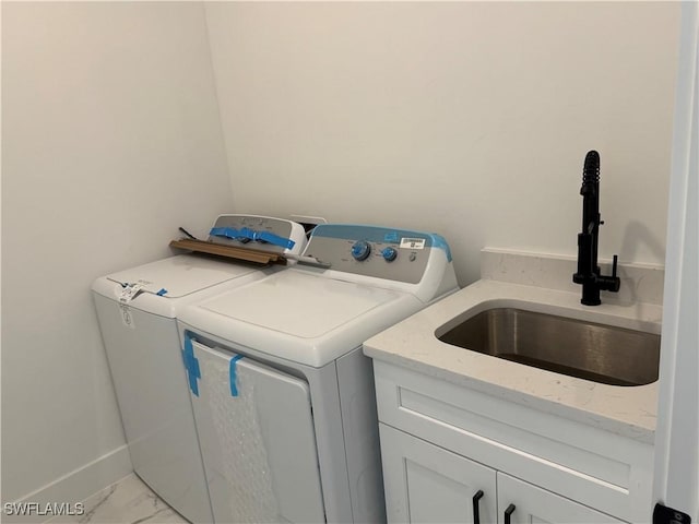 laundry room featuring cabinets, washer and clothes dryer, and sink