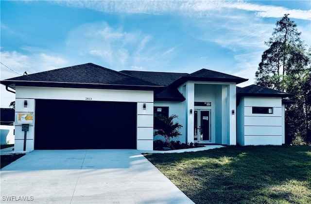 view of front of property with a garage and a front lawn