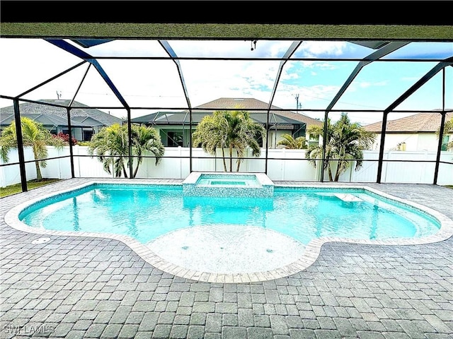 view of swimming pool with a lanai, a patio area, and an in ground hot tub