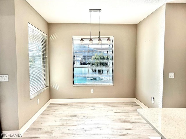 unfurnished dining area featuring light wood-type flooring