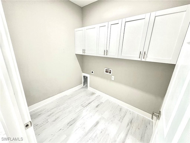 washroom with electric dryer hookup, washer hookup, light hardwood / wood-style flooring, and cabinets