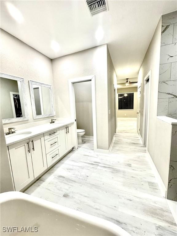 bathroom featuring hardwood / wood-style flooring, vanity, a bathtub, and toilet