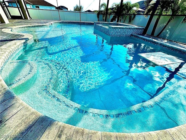 view of pool with an in ground hot tub