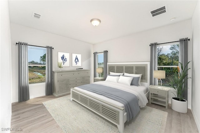 bedroom featuring multiple windows and light hardwood / wood-style flooring