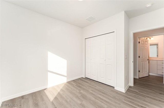 unfurnished bedroom with a closet and light hardwood / wood-style flooring