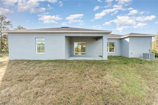 rear view of property with central air condition unit, a patio area, and a lawn